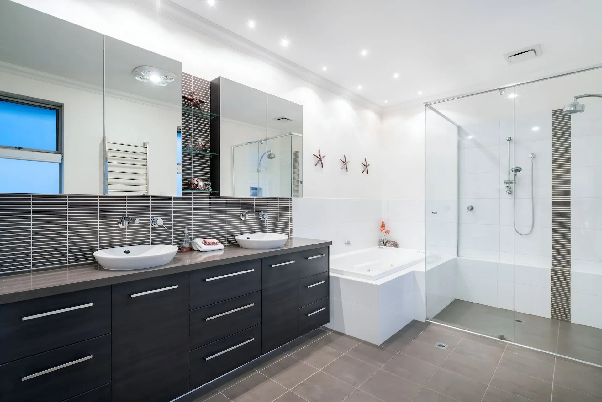 Wall-to-wall bathroom mirrors and shaving cabinets installed above a double vanity