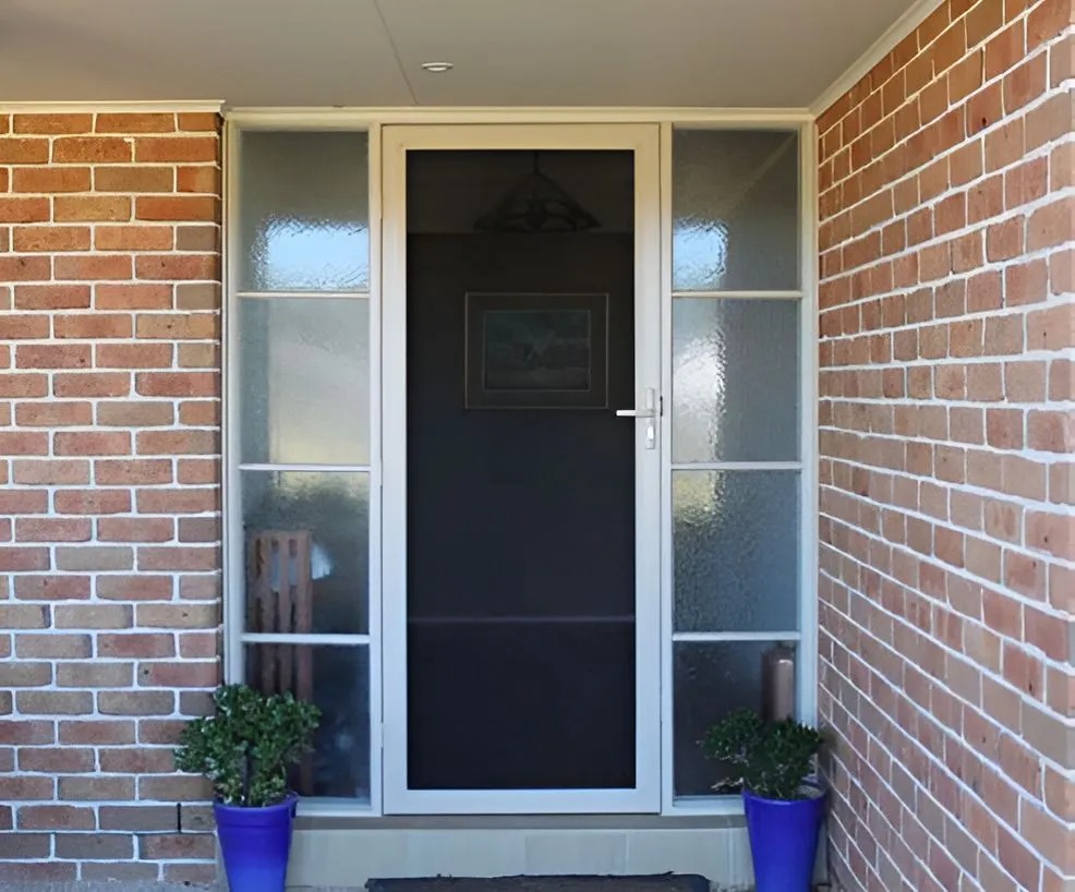 Durable security screen door installed on a brick home entry by All Hours Glass